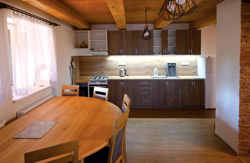 a kitchen with a wooden table and a dining room at Chata Jožka in Vyšné Ružbachy