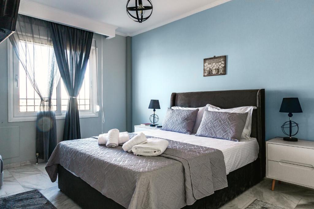 a blue bedroom with a bed with towels on it at Christinas apartment in Nea Moudania