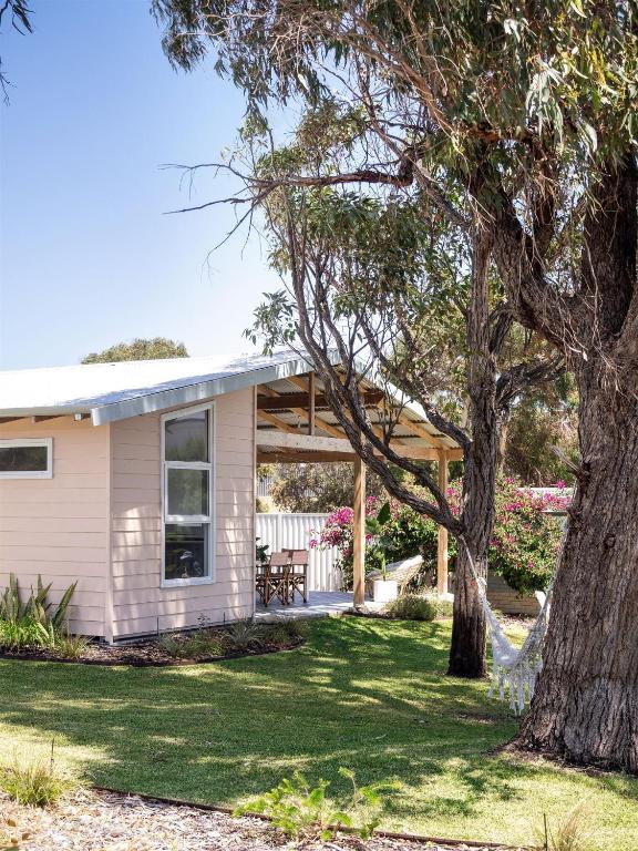 a small white house with a tree in the yard at Stylish Shack Falcon Bay in Wannanup