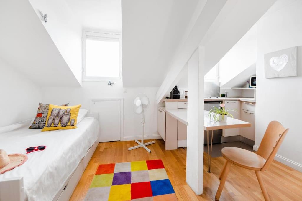 Cette chambre blanche comprend un lit, une table et une chaise. dans l'établissement Studio Renovated Chic Location, à Nice