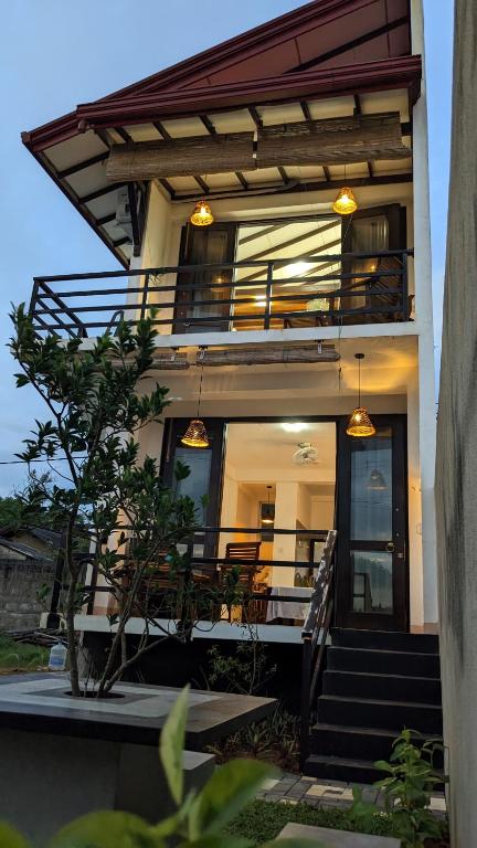 a house with stairs and a balcony with lights at Surf edge villa in Mawella