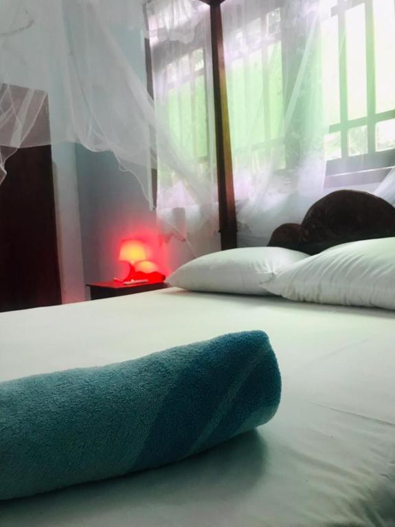 ヒッカドゥワにあるVilla Elena Innの青いタオルが付いたベッドの上