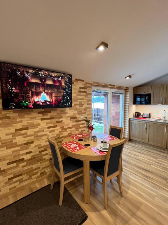 Apartament Vanessa 2 u podnóża gór, nad jeziorem Czorsztyńskim في Harklowa: غرفة طعام مع طاولة وتلفزيون على جدار