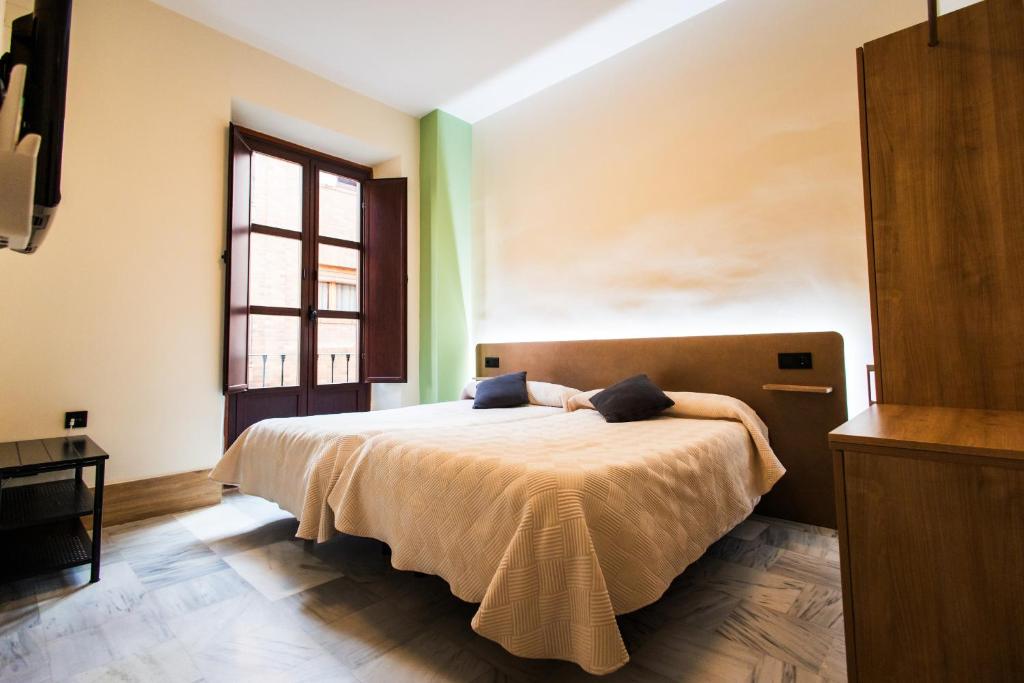 Posteľ alebo postele v izbe v ubytovaní Apartamentos Reyes Católicos