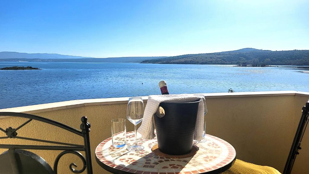 a table with two glasses and a bottle of wine at Sveti Duh Apartment Seaview in Posedarje
