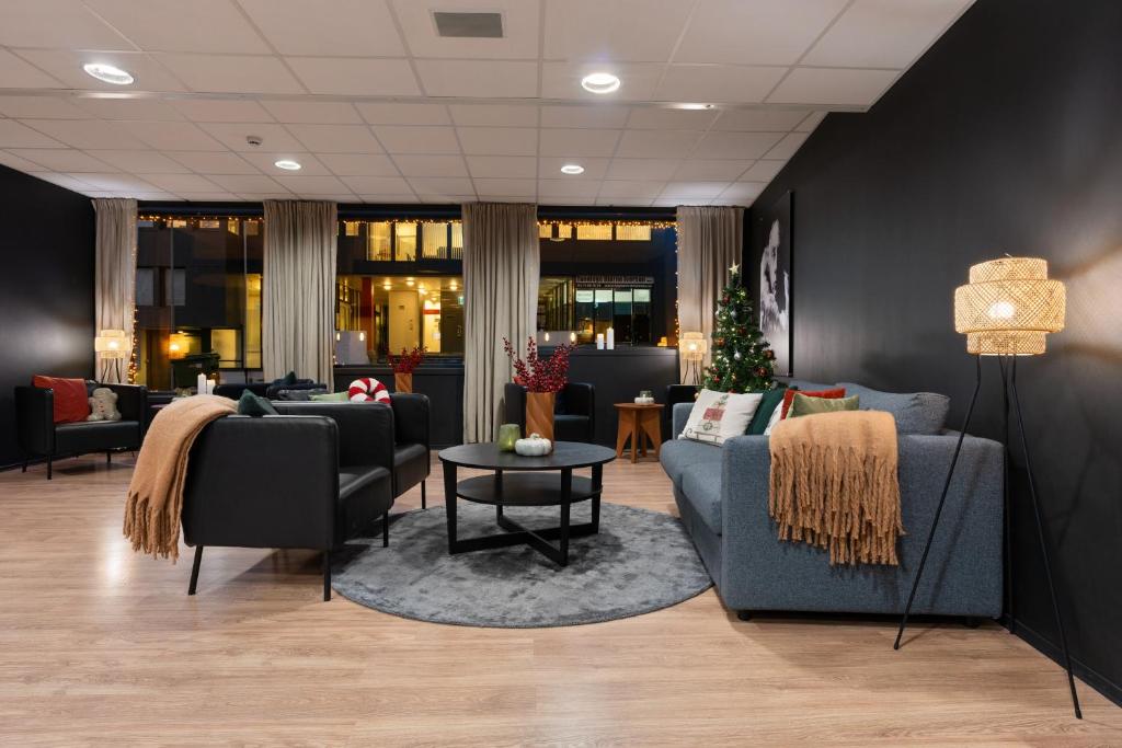 トロムソにあるEnter Skansen Hotelの長椅子とクリスマスツリーのある待合室