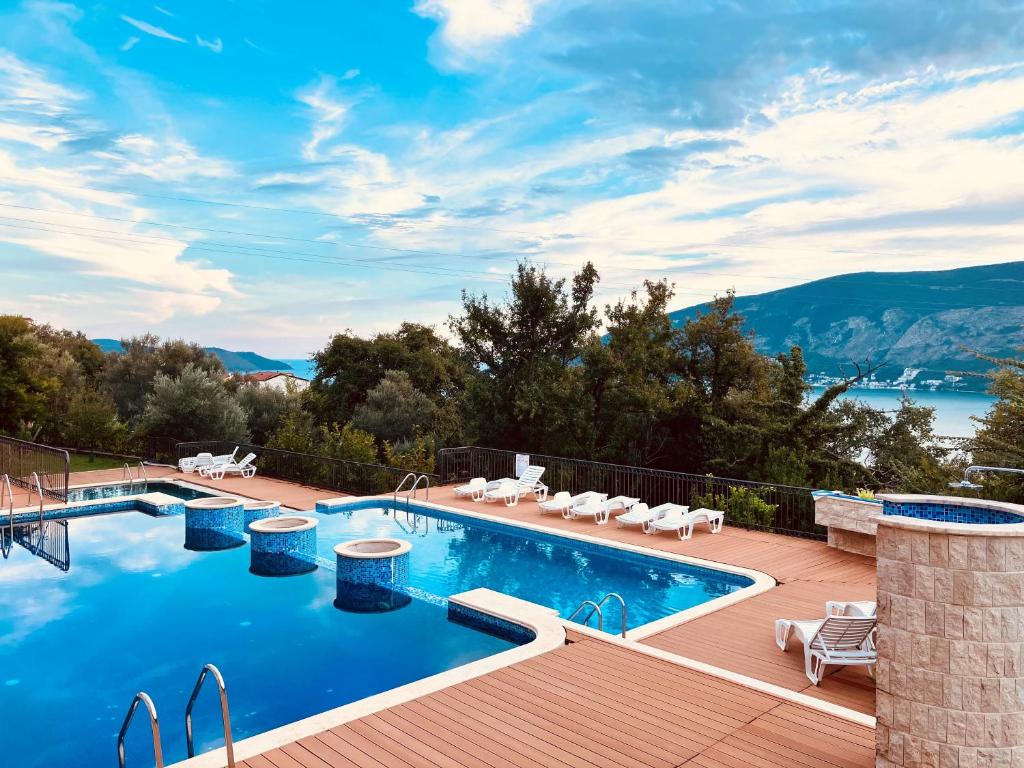 ein Pool auf einer Terrasse mit Blick auf das Wasser in der Unterkunft Adria Montenegro Seaview in Herceg-Novi