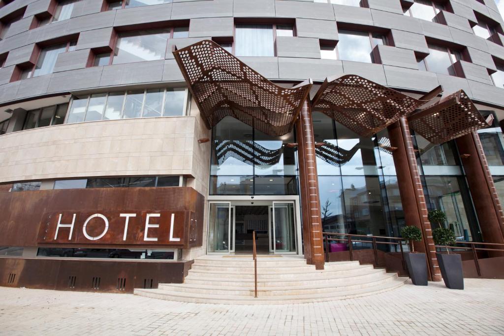 un edificio de hotel con una escalera de caracol delante de él en Hotel MasMonzon, en Monzón