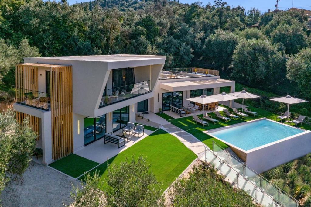 an aerial view of a house with a swimming pool at Villa Optima by Villa Plus in Peroúlion