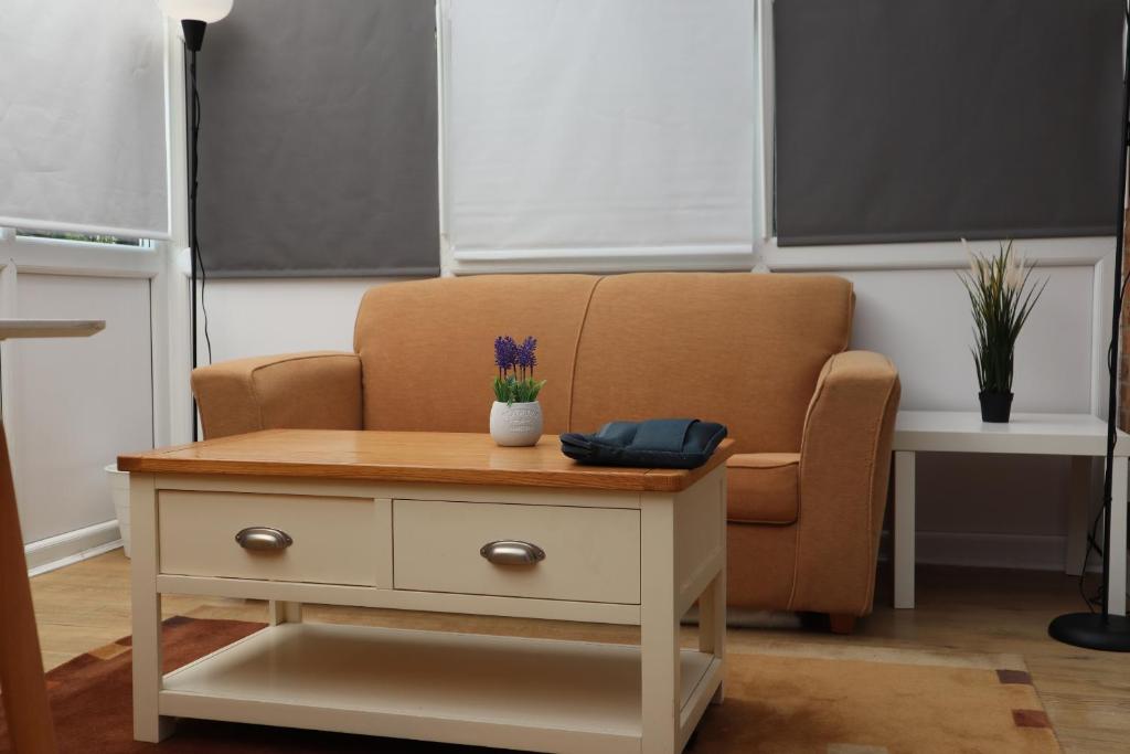 Una sala de estar con una silla y una mesa. en Heron House, en Thrapston