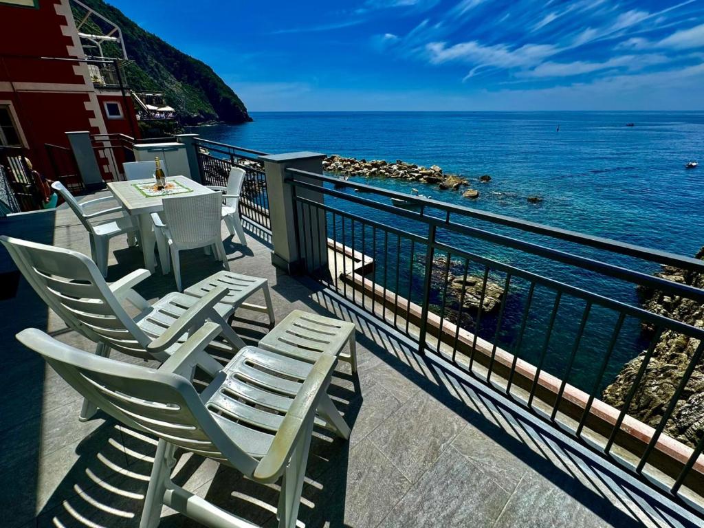 a balcony with chairs and a table and the ocean at la Chiglia in Riomaggiore