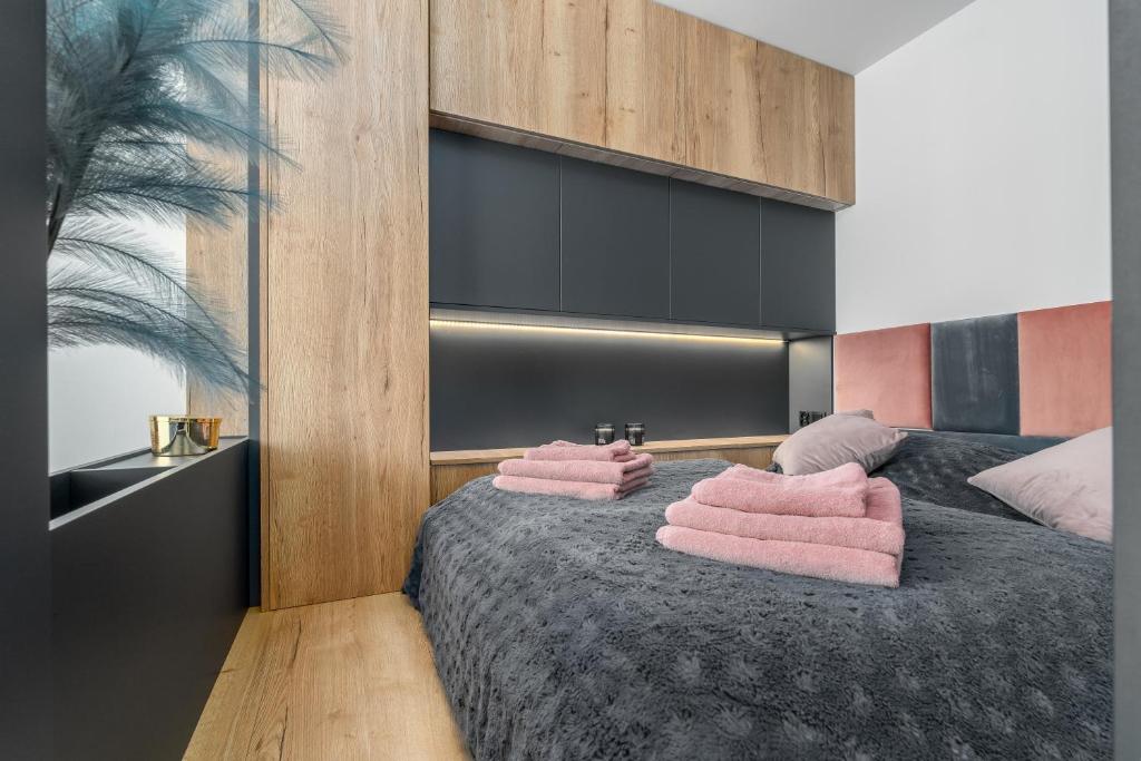 een slaapkamer met roze handdoeken op een bed bij Apartament Flaming Hanza Tower in Szczecin