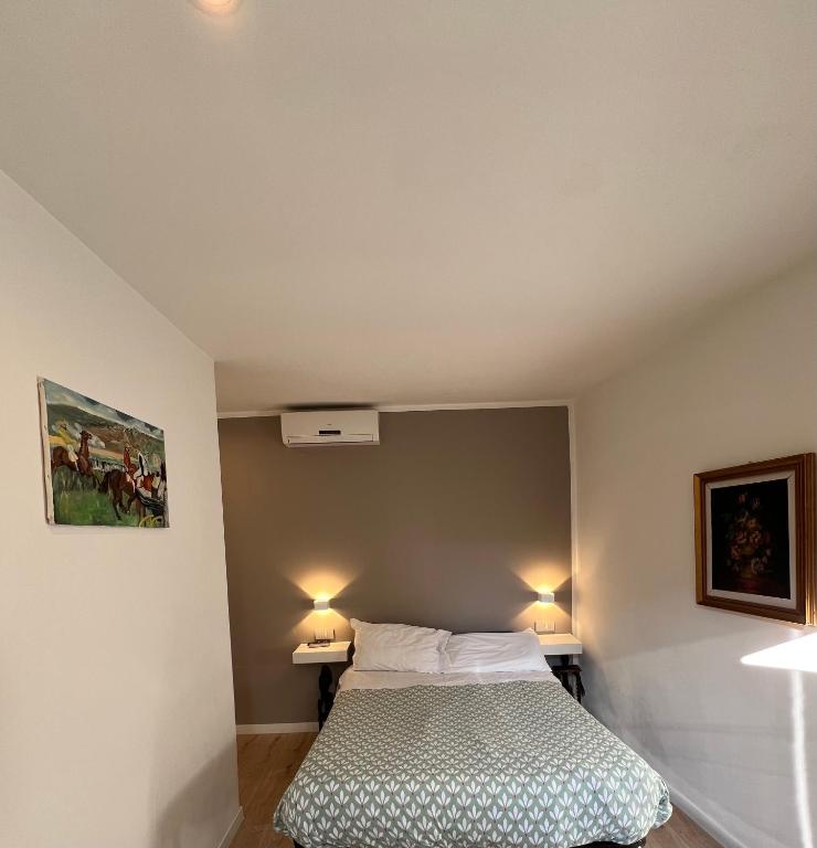 a bedroom with a bed and two lights on the wall at Casa vacanze Manzoni 287 PT in Perugia