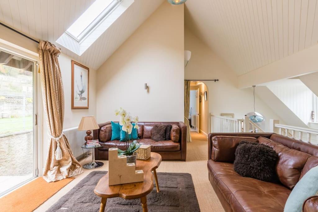 una sala de estar con un sofá y una mesa en The Chairman's Retreat in The Cotswolds - Space To Relax, en Gloucestershire