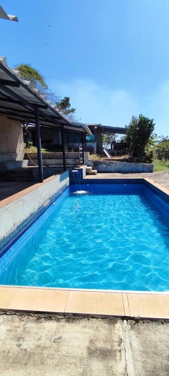 a large blue swimming pool with blue water at Chácara 2 Marias in Novo Gama