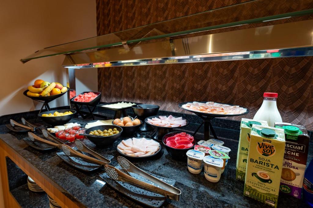 a buffet with bowls of food on a counter at ASA Hotel La Marina in Ondara