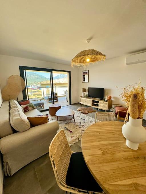 un salon avec une table et un canapé dans l'établissement Magnifique appart T3 vue mer, à Propriano