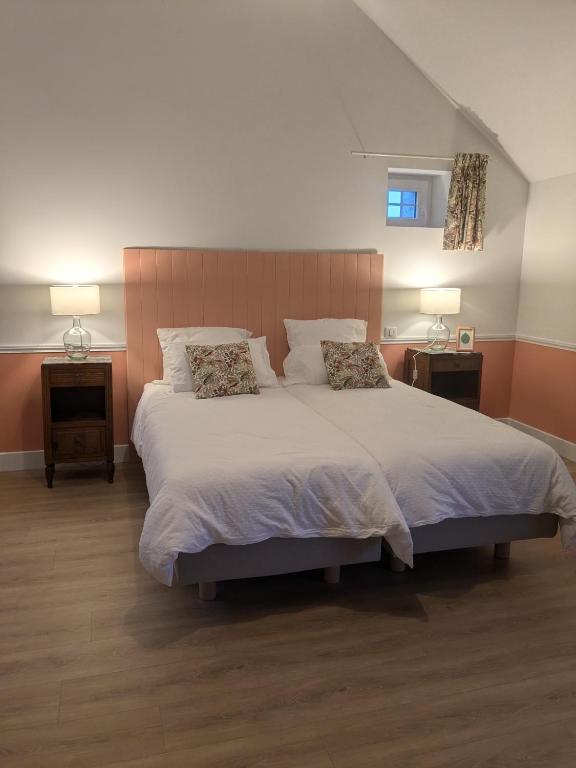 une chambre avec un grand lit avec deux oreillers dans l'établissement La Maison Cornon, à Trumilly