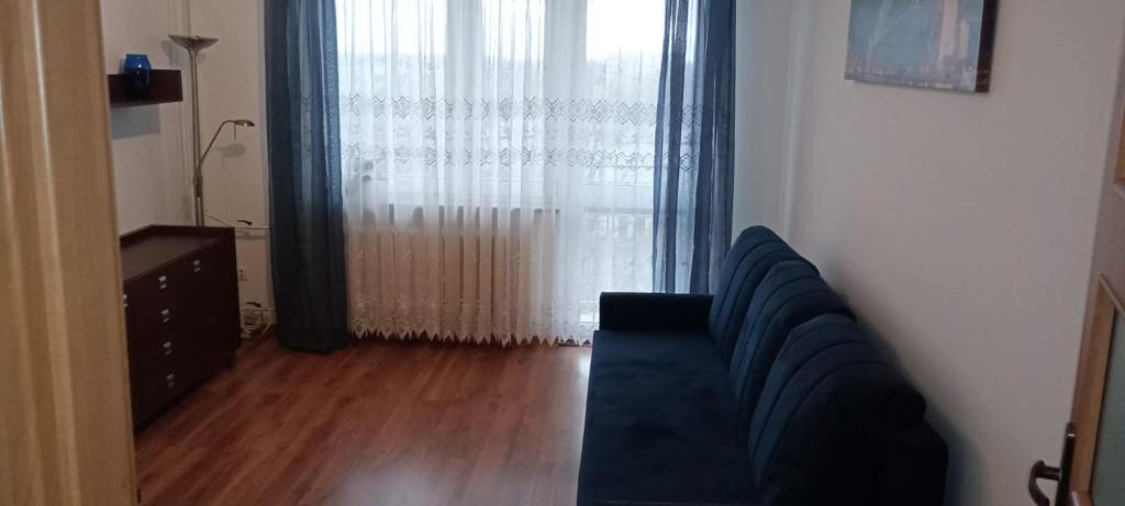 een woonkamer met een bank en een groot raam bij Apartament WARSZAWSKA in Kielce