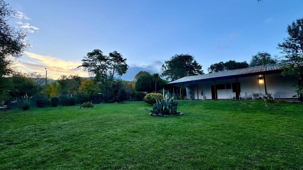 a house in a yard with a green lawn at Bayas Coloradas, San Lorenzo, Salta in San Lorenzo