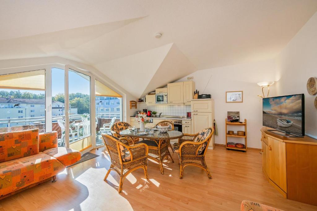 een woonkamer met een tafel en stoelen bij Düneneck 32 in Zempin