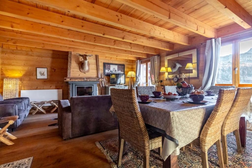 a dining room and living room with a table and chairs at Authentique chalet montagnard in Isola 2000