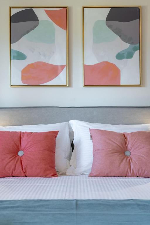 a bed with two red pillows in a bedroom at Villa Marathi with stunning ocean view in Chania Town