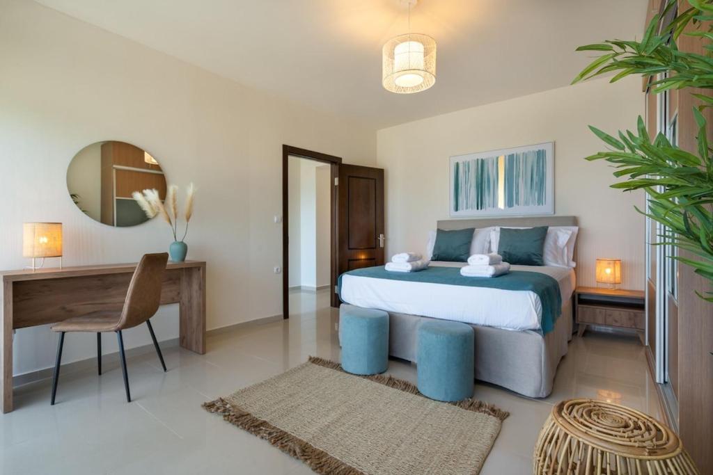 a bedroom with a bed and a table and a desk at Villa Marathi with stunning ocean view in Chania Town