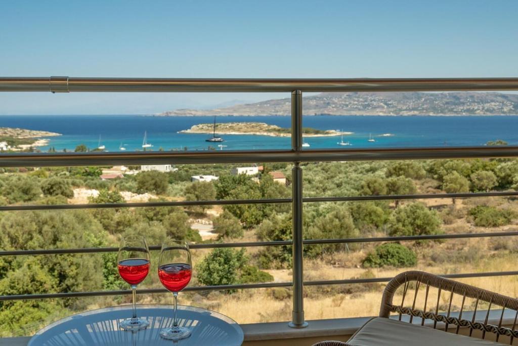 two glasses of wine on a table with a view of the ocean at Villa Marathi with stunning ocean view in Chania Town