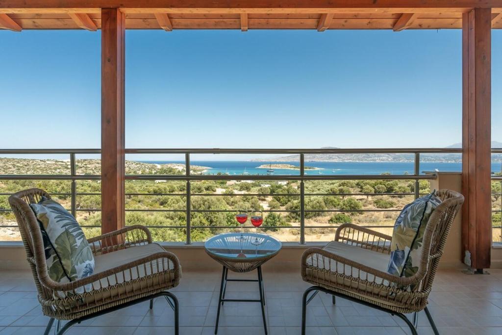 two chairs and a table on a balcony with a view at Villa Marathi with stunning ocean view in Chania Town