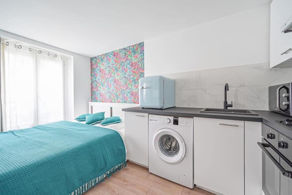 - une cuisine avec un lit et un lave-linge dans l'établissement Studio Paris Centre - Republique, à Paris
