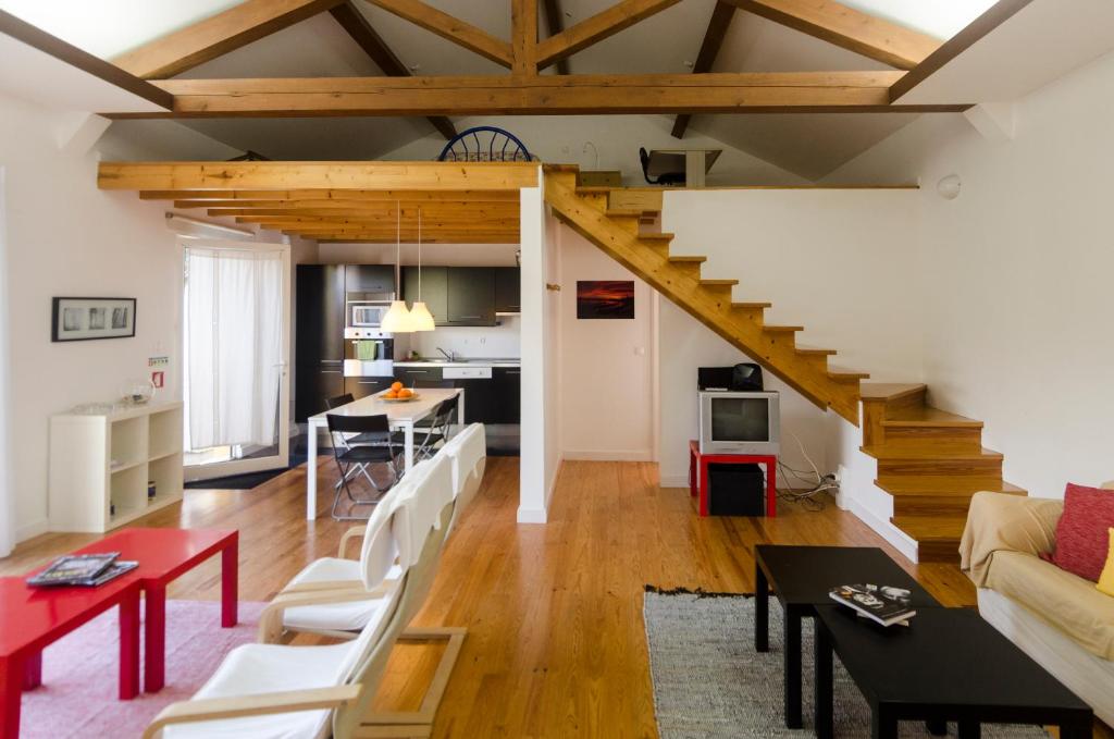 una sala de estar con techos de madera y una escalera. en Santana Houses, en Rabo de Peixe