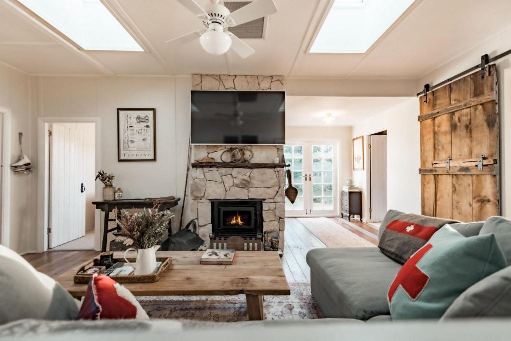 a living room with a couch and a fireplace at Lola Cottage in Adaminaby