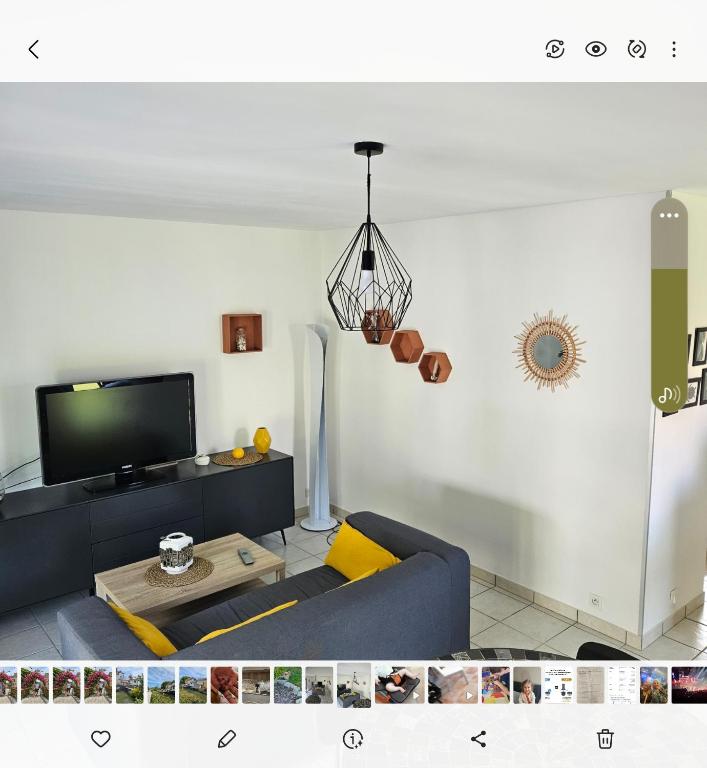 un salon avec un canapé bleu et une télévision dans l'établissement Les 6 chemins, à Saint-Nazaire