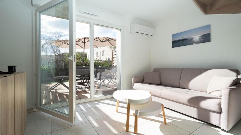 un salon avec un canapé et une table dans l'établissement La Dune 56 - VILLA 3P6, à Valras-Plage