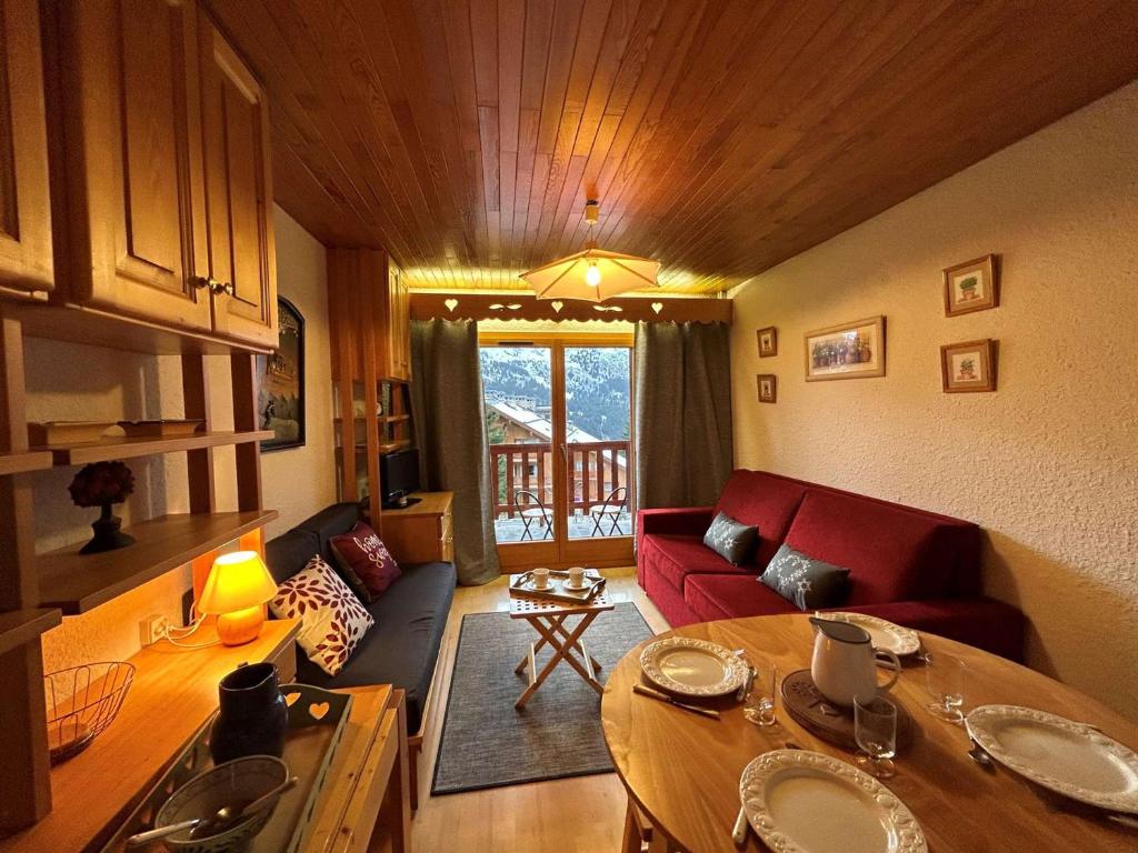un salon avec un canapé rouge et une table dans l'établissement Méribel: Charmant 2P, 4 Pers, proche commerces et pistes - FR-1-180-80, à Méribel
