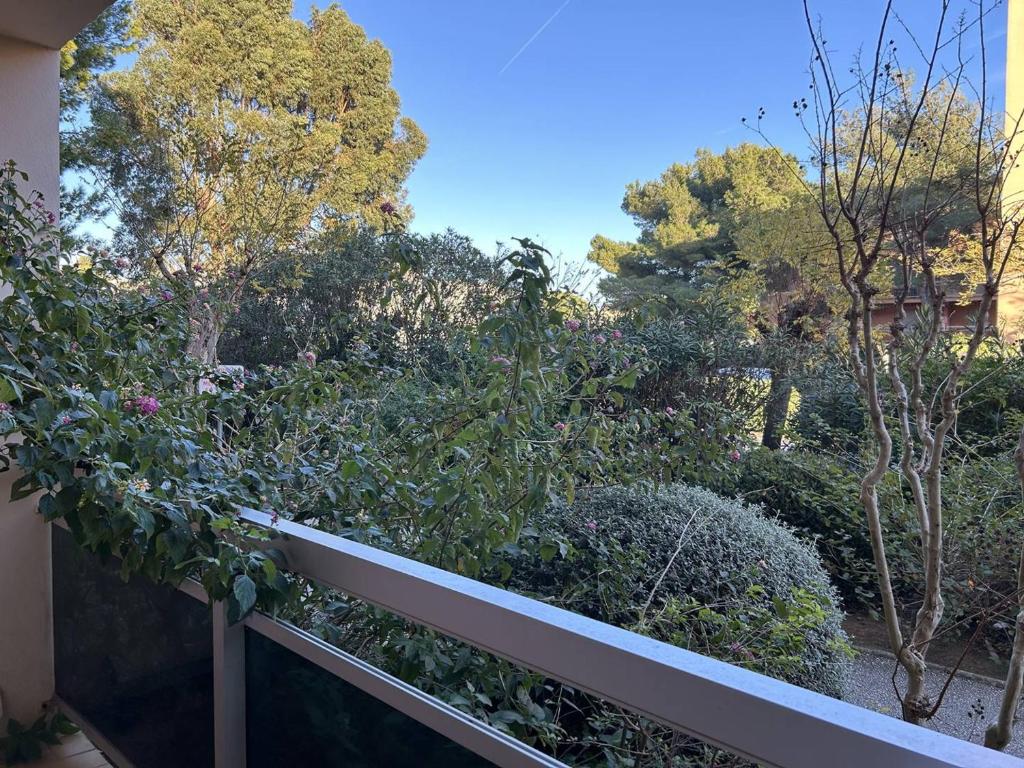 d'un balcon avec des arbres, des buissons et une clôture. dans l'établissement Appartement 2P 4 Pers avec Garage et Animaux Bienvenus - FR-1-251-848, à Bormes-les-Mimosas