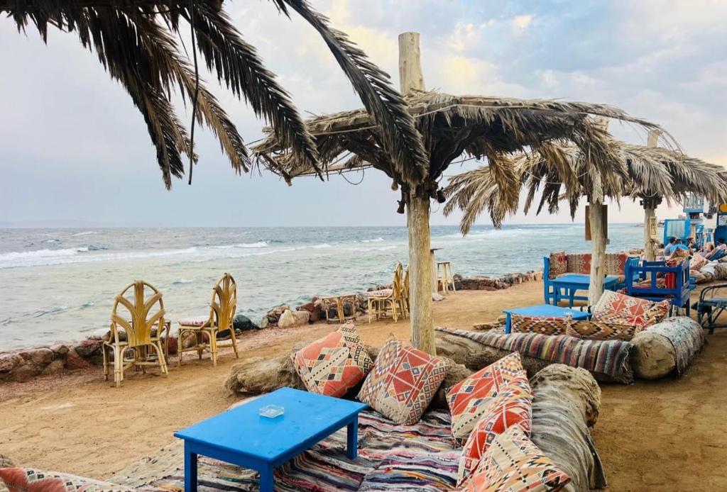 达哈布sphinx resort dahab的海滩上设有桌椅,大海上设有沙滩