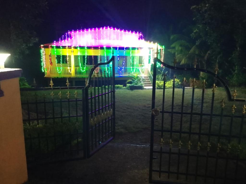 a gate with a building covered in christmas lights at Parvati Narayan Guest House in Sānikatta