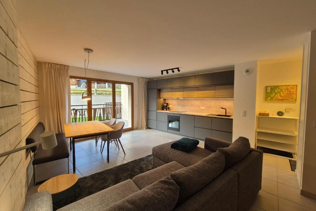 una sala de estar con un sofá y una mesa en Découvrez ce magnifique appartement au pied des pistes à La Féclaz, en La Féclaz