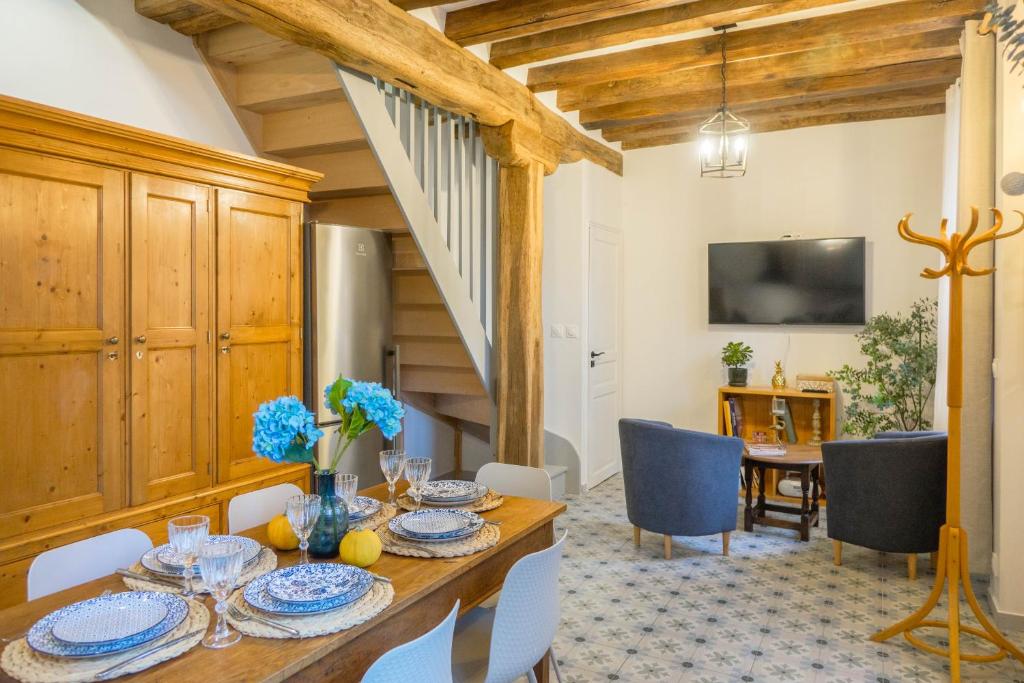 a dining room with a wooden table and chairs at La Maison de Jeanne - Cœur Historique d'Orléans avec parkings privés - classée 3 étoiles in Orléans