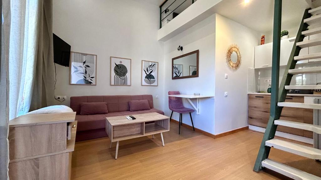 Una pequeña sala de estar con un sofá y una mesa. en Κομψό Πέτρινο Διαμέρισμα για Ζευγάρια - Apt IV, en La Canea