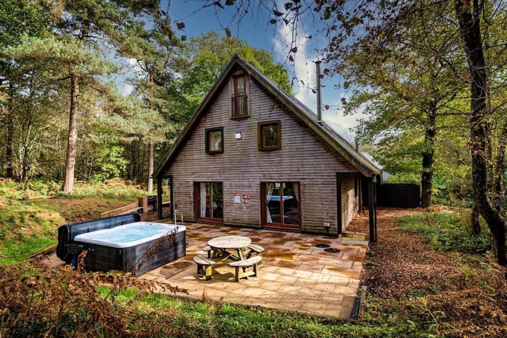 a large house with a pool in the yard at Stanton, woodland lodge with hot tub for 14 in Oakamoor