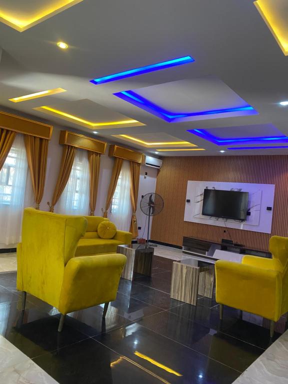 un soggiorno con mobili gialli e TV a schermo piatto di Ephpatha Apartment a Ibadan