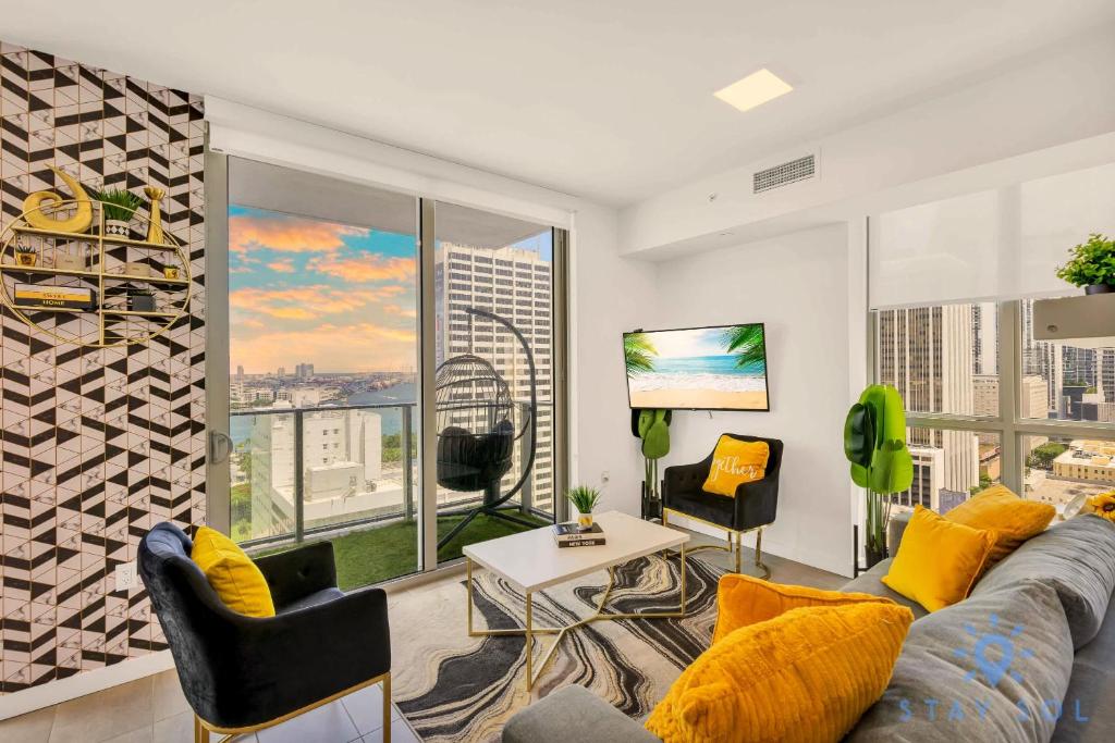 a living room with a couch and a large window at Beautiful Apartment with gym and amazing Pool in Miami