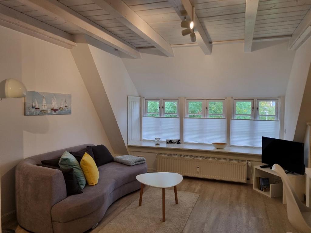 a living room with a couch and a tv at Reetglück in Wrixum