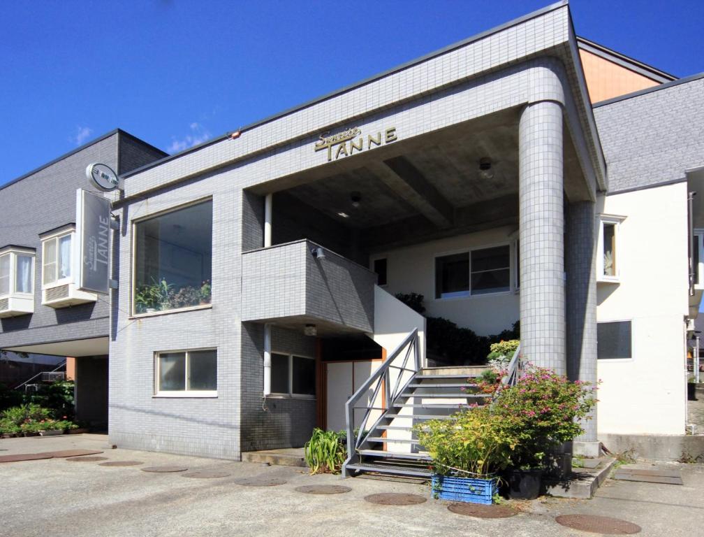 a building with a sign on the front of it at Hakuba Tsugaike Sunrise Tanne in Otari