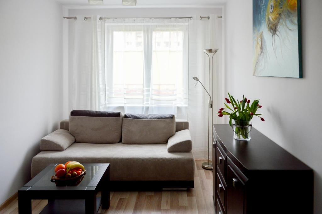 a living room with a couch and a table at Apartament Szczecin Pomorzany in Szczecin