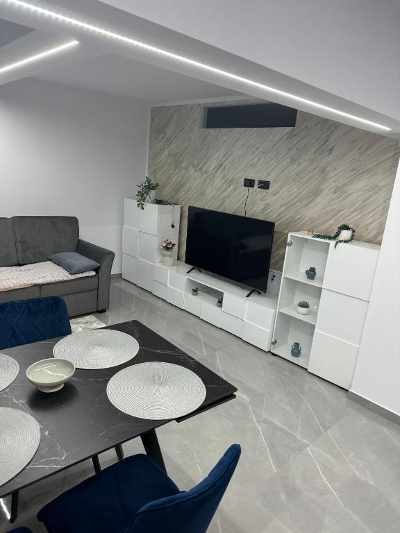 a living room with a table and a tv at Confort Apartament in Borsa