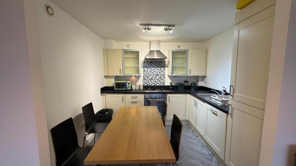 a small kitchen with a wooden table in it at The Metro Oasis in Edinburgh